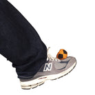 Orange and black hacky sack on foot