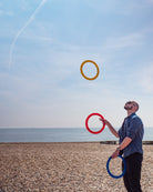 performer with 3 rings on a beach