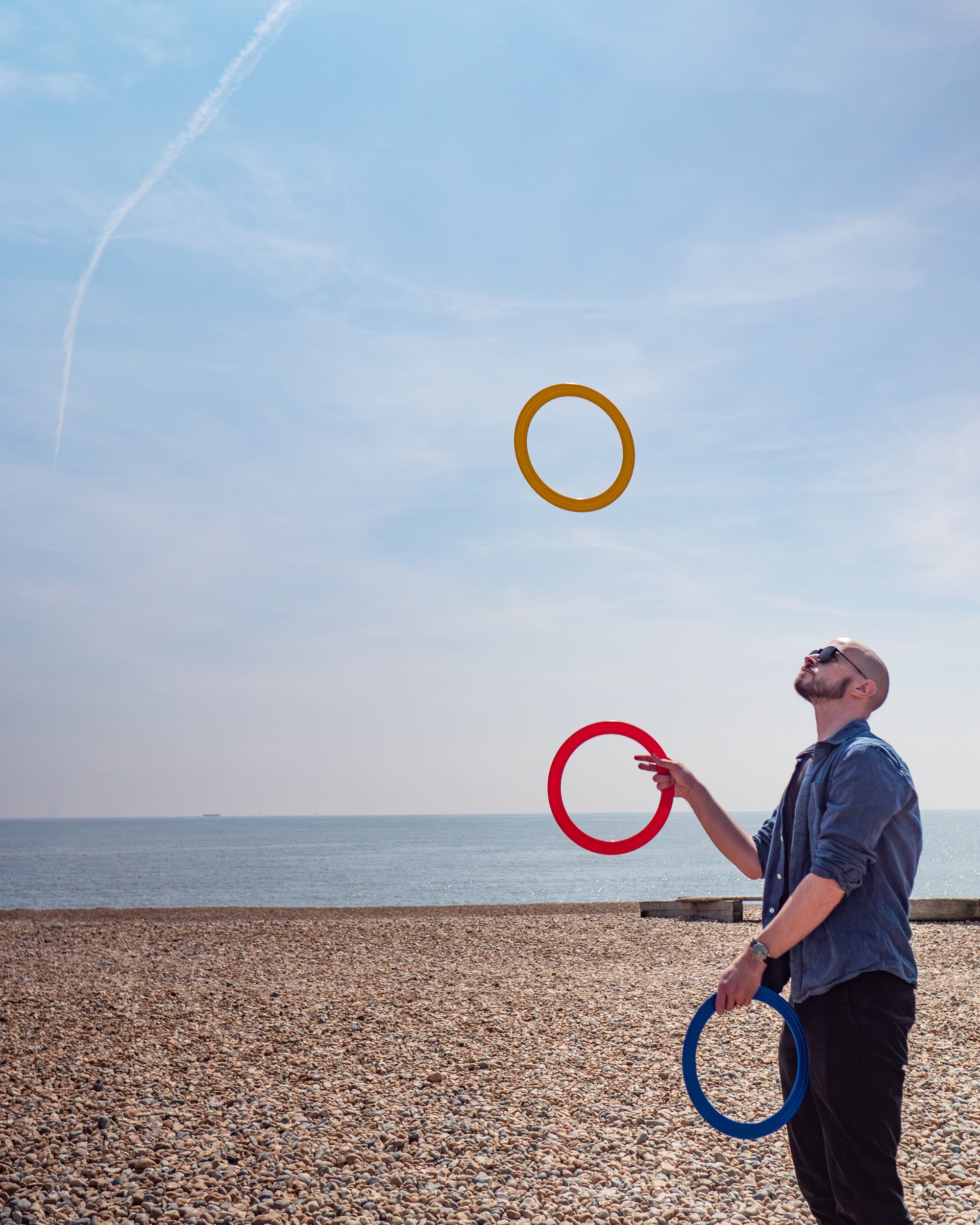 performer with 3 rings on a beach