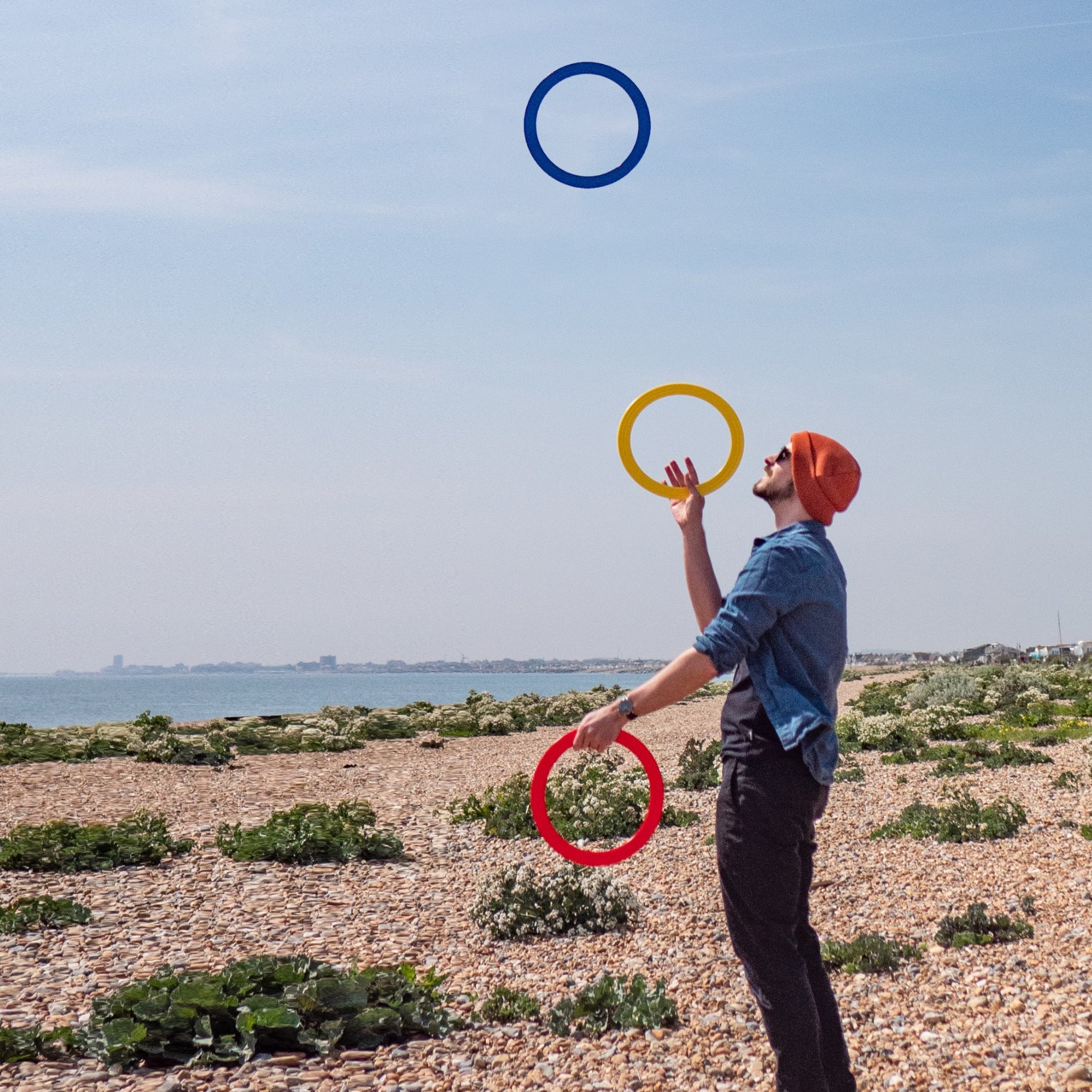 performer with 3 rings on a beach